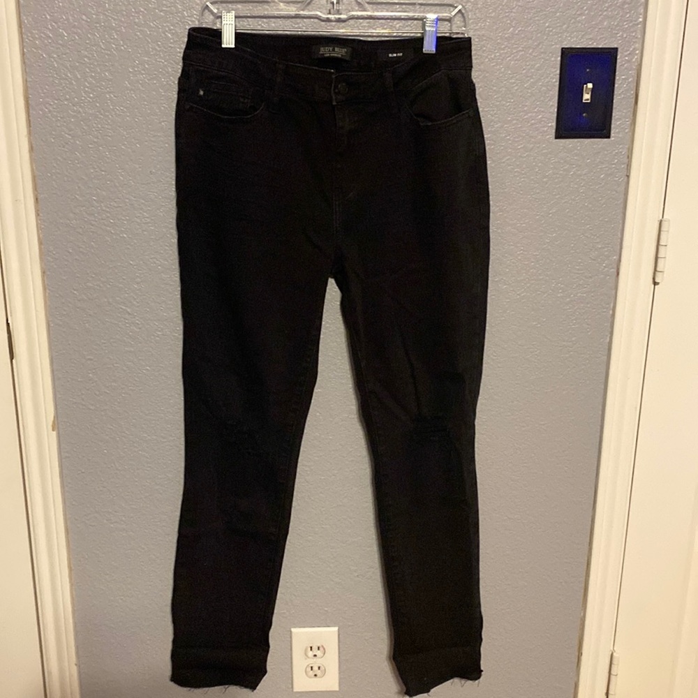 Judy Blue black distressed knee slim fit. Raw edge can be rolled.